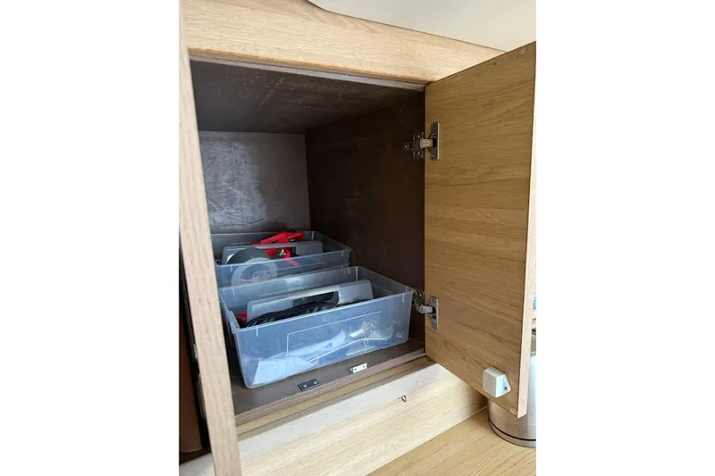 Manila Spirit Yacht Photos Pics Open wooden cabinet with plastic storage bins inside, Dean 5000 model, 2012.