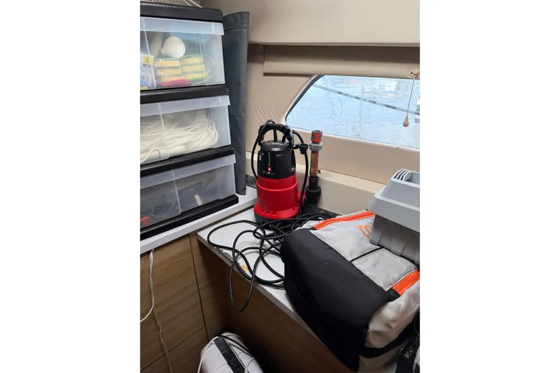 Manila Spirit Yacht Photos Pics Storage area with Dean 5000 equipment, plastic drawers, and window view.