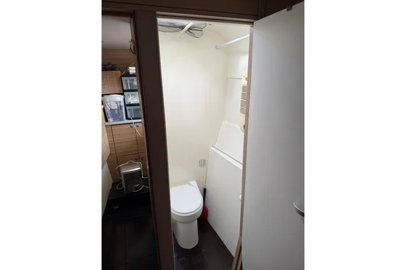 Manila Spirit Yacht Photos Pics Compact bathroom in 2012 Dean 5000 model, featuring toilet and storage shelves.