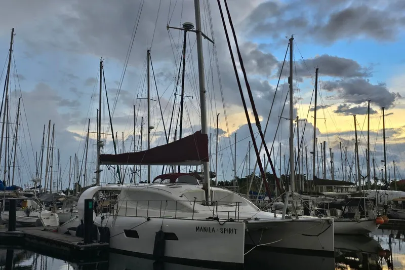 Manila Spirit Yacht Photos Pics Sailboats docked at marina during sunset, featuring a 2012 Dean 5000 catamaran.