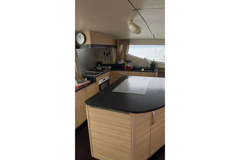 Manila Spirit Yacht Photos Pics Modern kitchen interior on a 2012 Dean 5000 yacht, featuring wood cabinetry and black countertops.