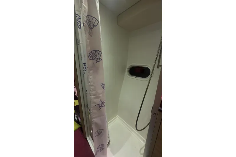 Manila Spirit Yacht Photos Pics Compact shower area with seashell-patterned curtain in a 2012 Dean 5000 model.