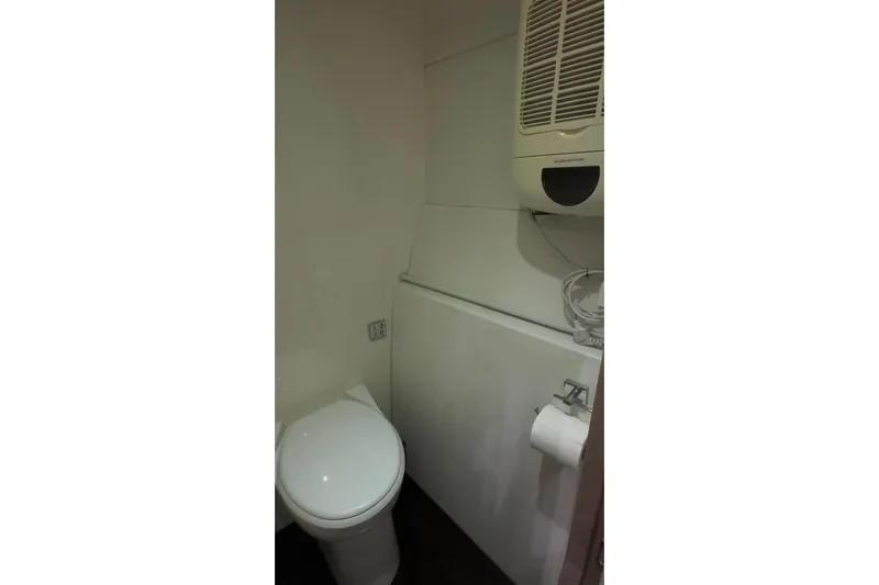 Manila Spirit Yacht Photos Pics Compact bathroom with toilet, wall heater, and toilet paper holder. Dean 5000, 2012 model.