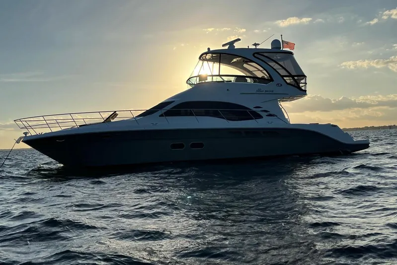 N/a Yacht Photos Pics 2006 Sea Ray 52 Sedan Bridge yacht silhouetted against sunset on open water.