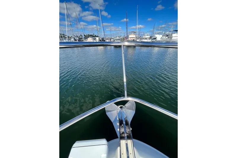 N/a Yacht Photos Pics Bow view of 2006 Sea Ray 52 Sedan Bridge in a marina, under blue skies.