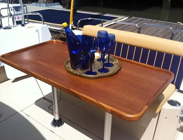 The Western Yacht Photos Pics Elegant wooden table on 2014 Ranger Tugs R-31CB with blue glasses and bottle.