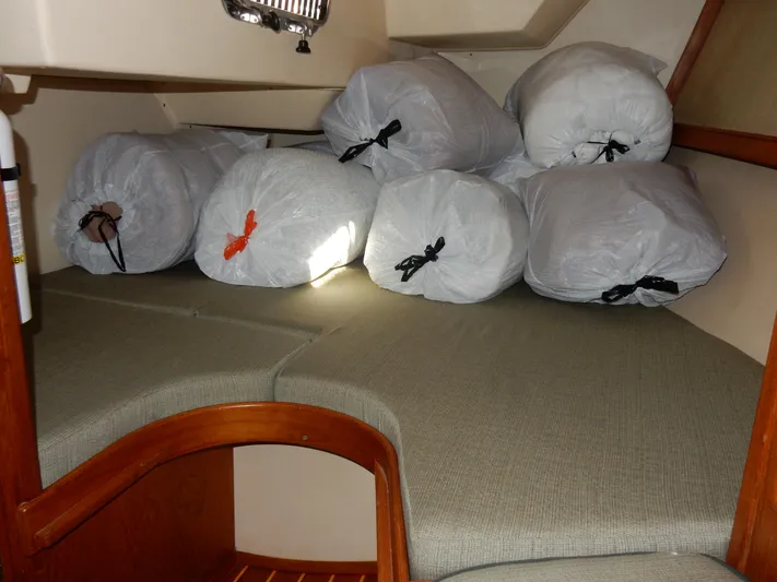 Tilikum III Yacht Photos Pics 1997 Island Packet 40 interior with storage bags on cushioned seating area.