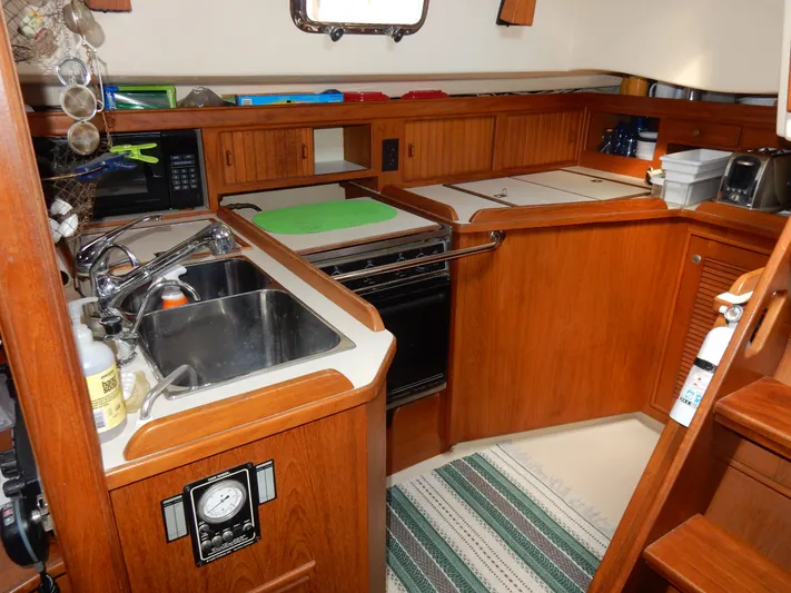 Tilikum III Yacht Photos Pics Island Packet 40 yacht kitchen, 1997 model, featuring wooden cabinetry and modern appliances.