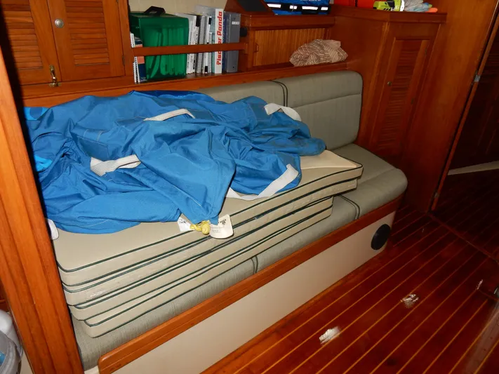 Tilikum III Yacht Photos Pics Interior of 1997 Island Packet 40 sailboat with cushions and blue fabric on wooden bench.