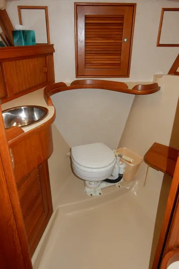 Tilikum III Yacht Photos Pics 1997 Island Packet 40 yacht bathroom with wooden cabinetry and compact design.