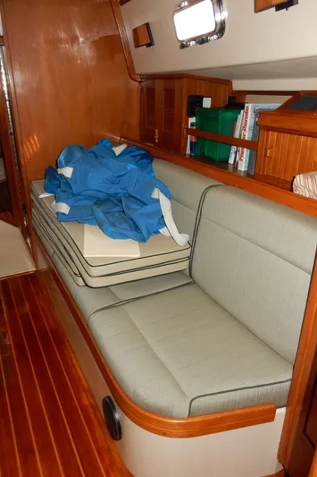 Tilikum III Yacht Photos Pics Interior of 1997 Island Packet 40 sailboat with cushioned seating and wooden flooring.