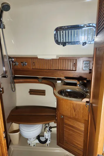 Tilikum III Yacht Photos Pics 1997 Island Packet 40 yacht bathroom with wooden cabinetry and stainless steel sink.