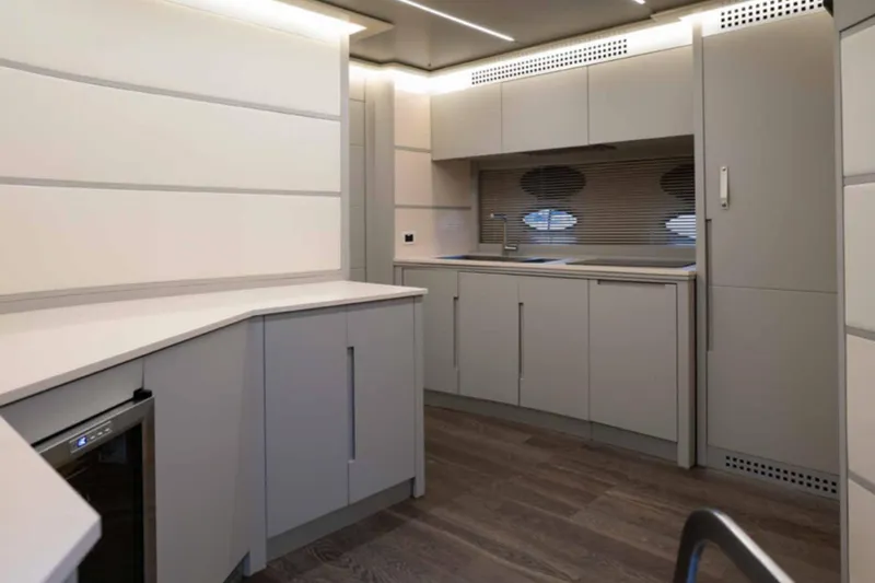 Yacht Photos Pics Modern kitchen interior on a 2005 Pershing 62 yacht, featuring sleek cabinetry and wood flooring.