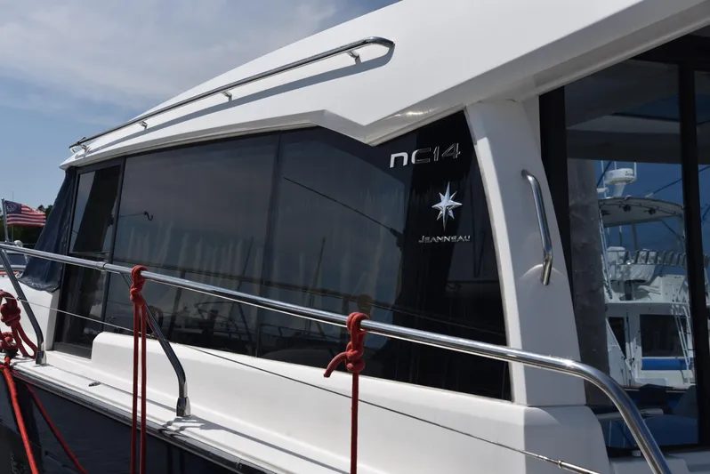 "freedom" Yacht Photos Pics 2016 Jeanneau NC 14 yacht with sleek design and modern windows, docked at marina.