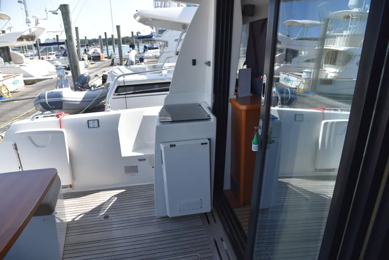 "freedom" Yacht Photos Pics 2016 Jeanneau NC 14 yacht deck with outdoor kitchenette and marina view.