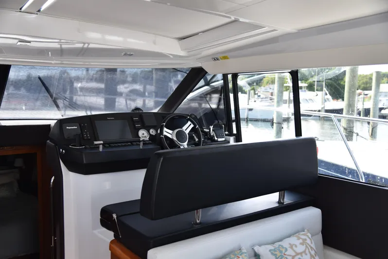 "freedom" Yacht Photos Pics Interior helm of 2016 Jeanneau NC 14 yacht with modern controls and seating.
