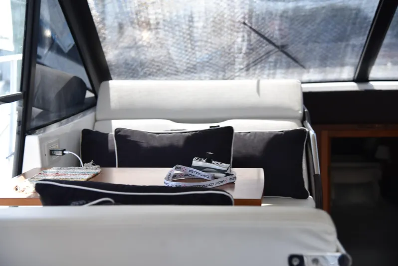 "freedom" Yacht Photos Pics Interior of 2016 Jeanneau NC 14 boat with cushioned seating and table.
