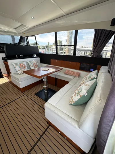 "freedom" Yacht Photos Pics 2016 Jeanneau NC 14 interior with elegant seating and wooden flooring.
