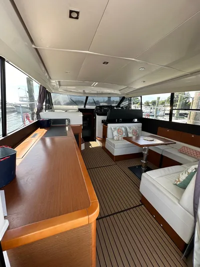 "freedom" Yacht Photos Pics Interior of 2016 Jeanneau NC 14 yacht with modern seating and wooden finishes.