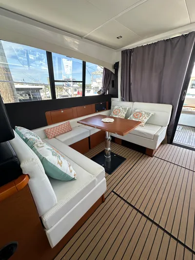 "freedom" Yacht Photos Pics Interior of 2016 Jeanneau NC 14 yacht with elegant seating and wooden table.