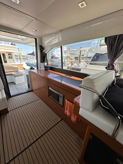 "freedom" Yacht Photos Pics Interior of 2016 Jeanneau NC 14 yacht with modern furnishings and marina view.