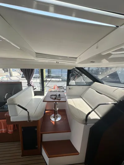 "freedom" Yacht Photos Pics Interior of 2016 Jeanneau NC 14 yacht with white seating and table.