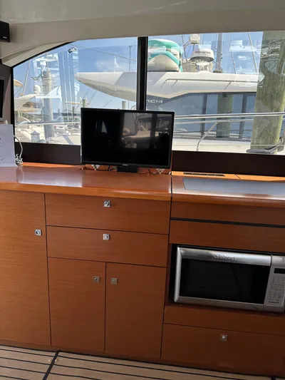 "freedom" Yacht Photos Pics Interior of 2016 Jeanneau NC 14 yacht with wooden cabinetry and modern appliances.
