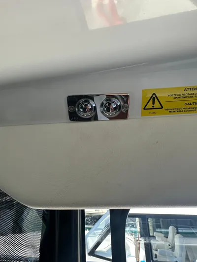 "freedom" Yacht Photos Pics Interior detail of a 2016 Jeanneau NC 14 boat, featuring a warning label and light fixtures.