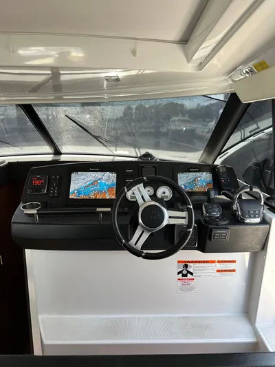 "freedom" Yacht Photos Pics 2016 Jeanneau NC 14 helm with navigation screens and steering wheel.