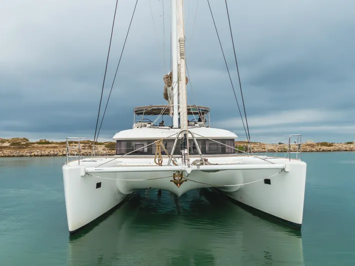 Sunset O Yacht Photos Pics 2019 Lagoon 620 catamaran on calm water under cloudy sky.