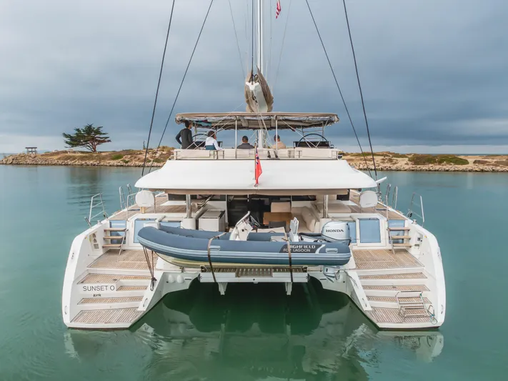 Sunset O Yacht Photos Pics 2019 Lagoon 620 catamaran docked, featuring a tender boat on the stern.