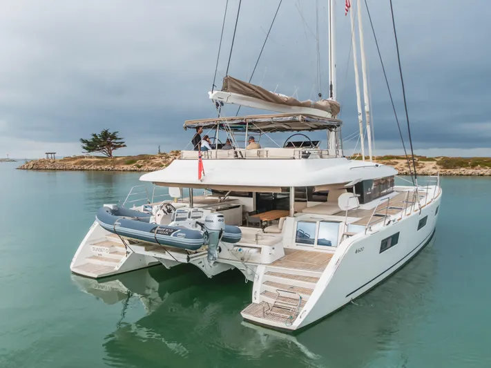 Sunset O Yacht Photos Pics 2019 Lagoon 620 catamaran on calm water, featuring spacious deck and modern design.