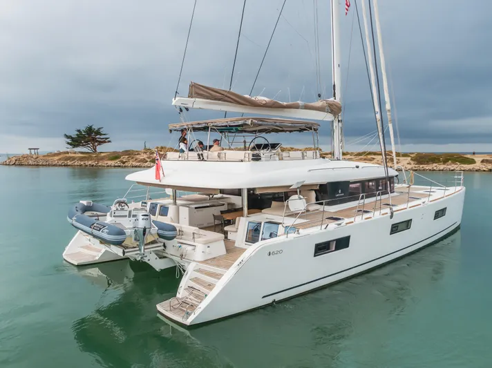 Sunset O Yacht Photos Pics 2019 Lagoon 620 catamaran sailing in calm waters, featuring a spacious deck and modern design.