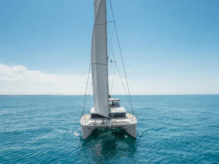 Sunset O Yacht Photos Pics 2019 Lagoon 620 catamaran sailing on clear blue ocean waters.