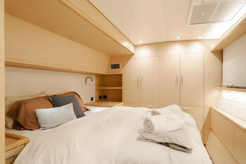 Sunset O Yacht Photos Pics Luxurious bedroom interior of 2019 Lagoon 620 yacht with cozy bedding and modern design.