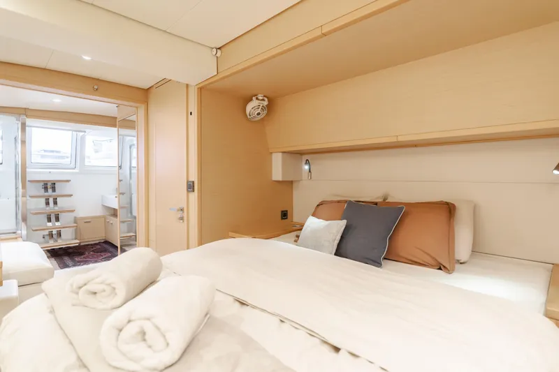 Sunset O Yacht Photos Pics Luxurious bedroom interior of 2019 Lagoon 620 yacht with cozy bedding and modern design.