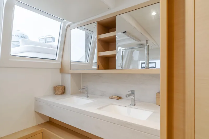 Sunset O Yacht Photos Pics Luxurious bathroom in 2019 Lagoon 620 yacht with dual sinks and modern fixtures.