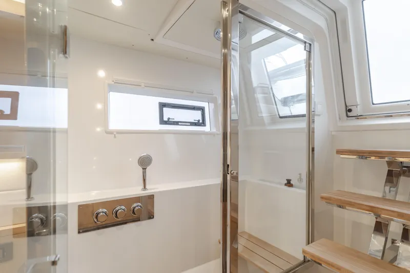 Sunset O Yacht Photos Pics Luxurious bathroom interior of 2019 Lagoon 620 yacht with modern fixtures and wooden accents.