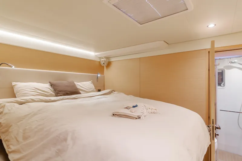 Sunset O Yacht Photos Pics Luxurious bedroom interior of 2019 Lagoon 620 yacht with cozy bedding and modern lighting.