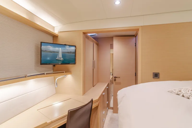 Sunset O Yacht Photos Pics Luxurious interior of 2019 Lagoon 620 yacht with desk, TV, and bed.