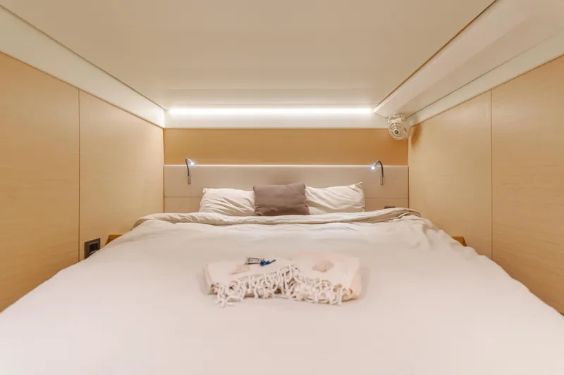 Sunset O Yacht Photos Pics Luxurious bedroom interior of 2019 Lagoon 620 yacht with cozy bedding and ambient lighting.