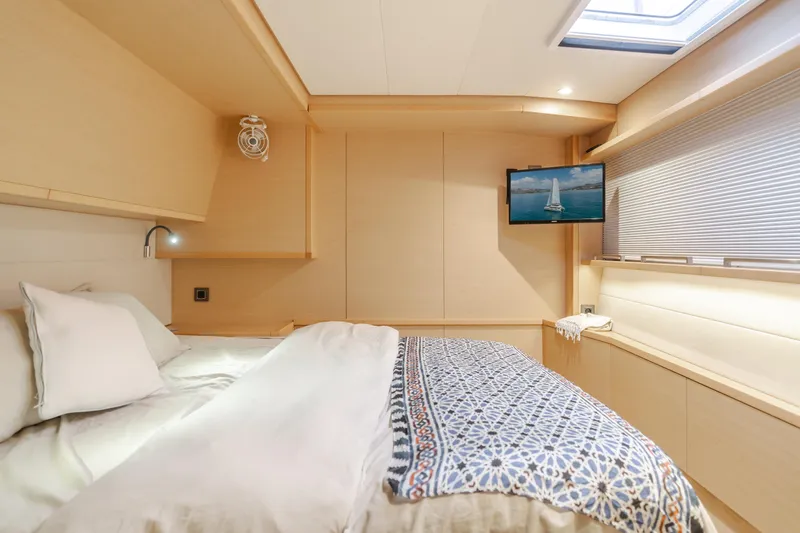 Sunset O Yacht Photos Pics Luxurious bedroom interior of 2019 Lagoon 620 yacht with modern decor and natural lighting.