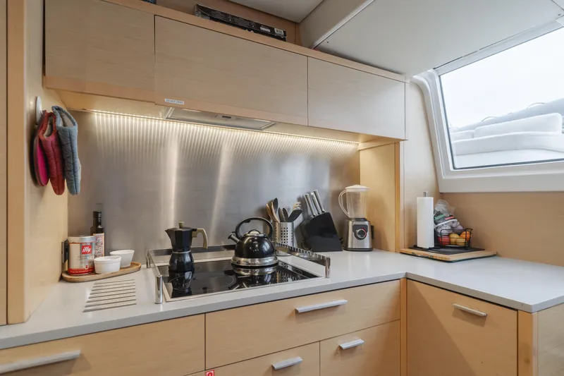 Sunset O Yacht Photos Pics Modern kitchen in 2019 Lagoon 620 yacht with appliances and wooden cabinetry.