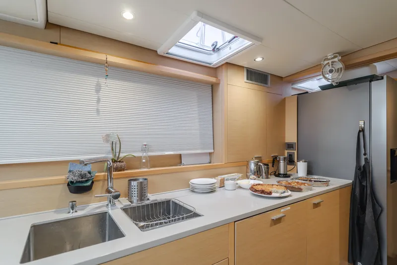 Sunset O Yacht Photos Pics Modern kitchen interior of 2019 Lagoon 620 yacht with sleek countertops and appliances.