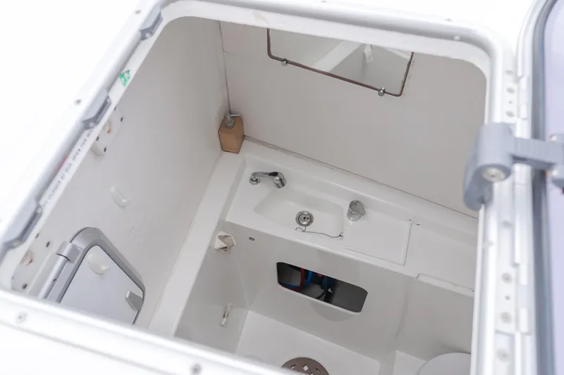 Sunset O Yacht Photos Pics 2019 Lagoon 620 yacht bathroom with sink, mirror, and compact design.
