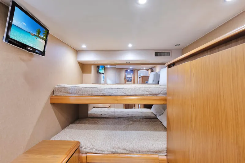 Cutter Bill Yacht Photos Pics Interior of 2011 Viking 70 Convertible yacht with bunk beds and wall-mounted TV.