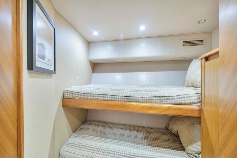 Cutter Bill Yacht Photos Pics Bunk beds in 2011 Viking 70 Convertible yacht cabin, featuring cozy bedding and soft lighting.