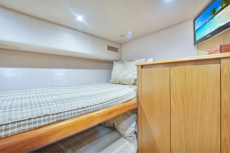 Cutter Bill Yacht Photos Pics Cozy cabin interior of 2011 Viking 70 Convertible yacht with bunk bed and TV.