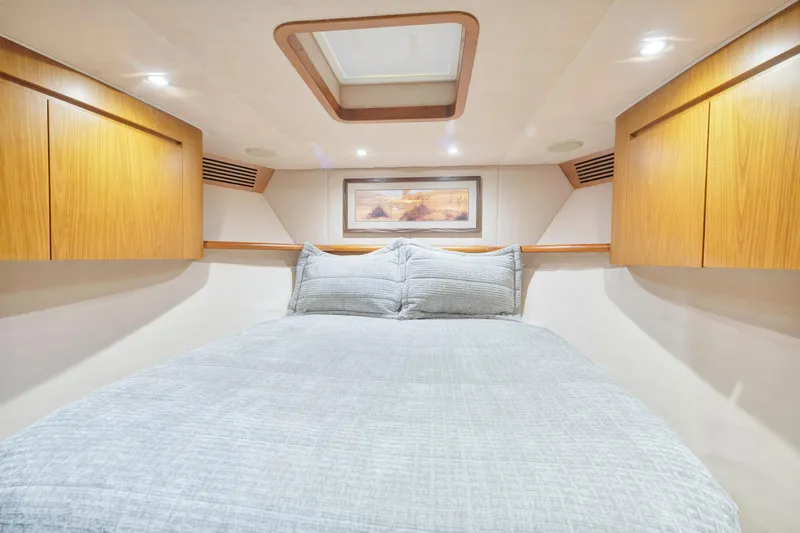 Cutter Bill Yacht Photos Pics Luxurious bedroom interior of 2011 Viking 70 Convertible yacht with wood cabinets and skylight.