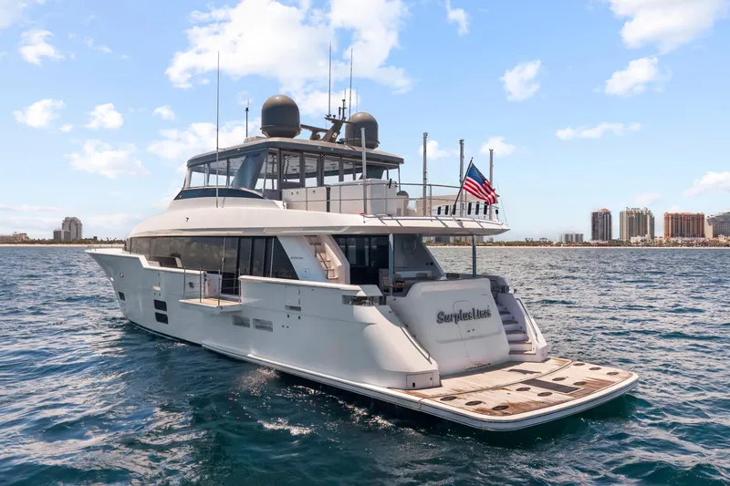 Surplus Lines Yacht Photos Pics 2019 Hatteras M90 Panacera yacht on open water, city skyline in background.